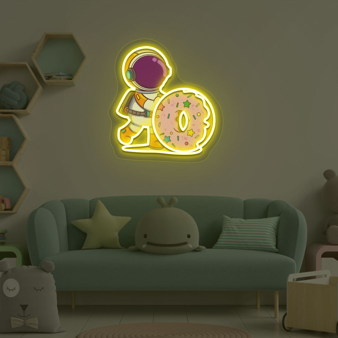A space-themed kids' room with a yellow LED astronaut holding a doughnut neon sign. Perfect for kids’ rooms, nurseries, bedroom wall décor, and space-themed interiors.