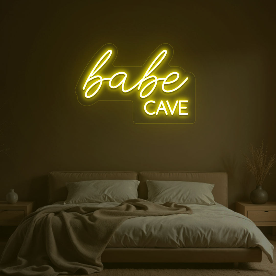 Stylish yellow LED babe cave neon sign glowing on the wall. Perfect for bedroom wall décor, dressing rooms, personal spaces, and gifts.