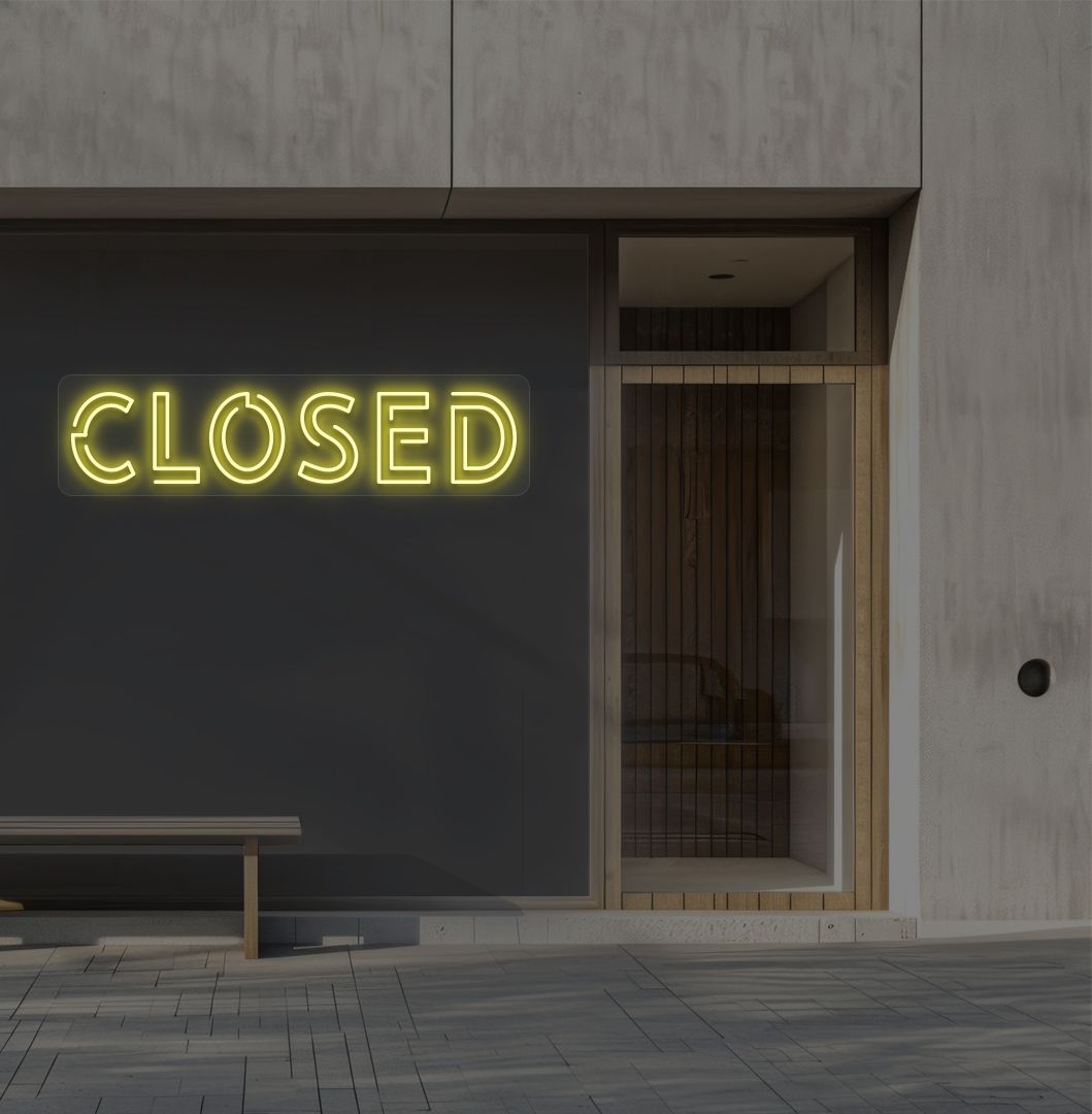 Image of a closed bold neon sign glowing on a shop exterior wall in yellow.