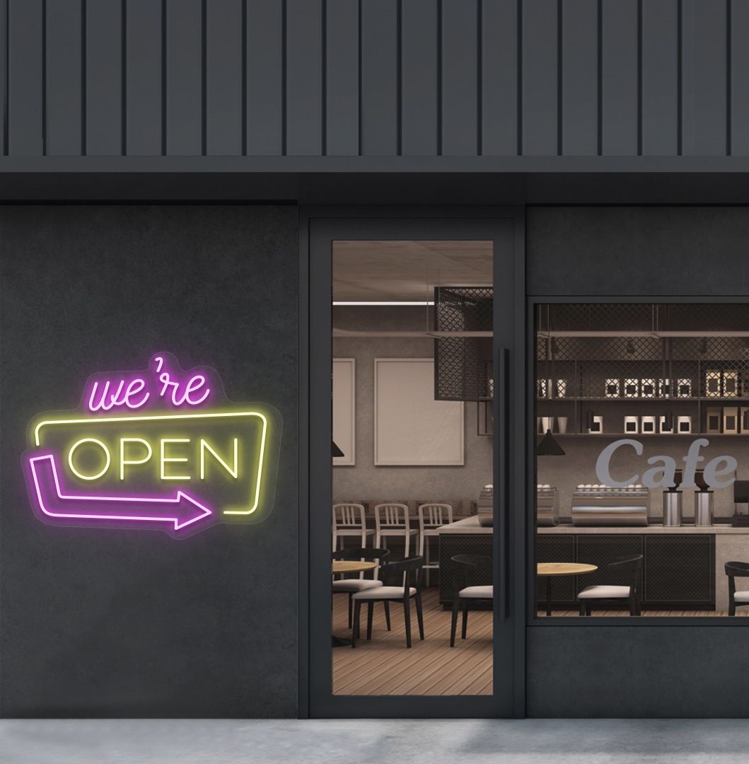 Cafe outdoor wall with a "We're Open" arrow neon sign glowing yellow. Perfect for café outdoor walls, storefront signage, restaurants, and commercial spaces.