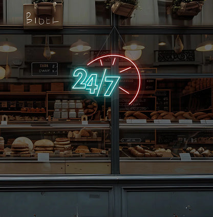 Trendy 24/7 with clock neon sign in ice blue hanging on bakery storefront glass.