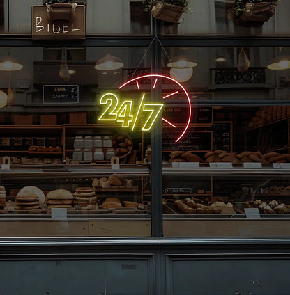 Yellow LED 24/7 clock neon sign glowing on bakery glass storefront.