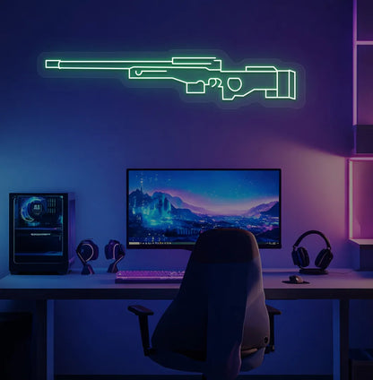 Green "AWM gaming gun" LED neon sign glowing blue on aesthetic gaming room.