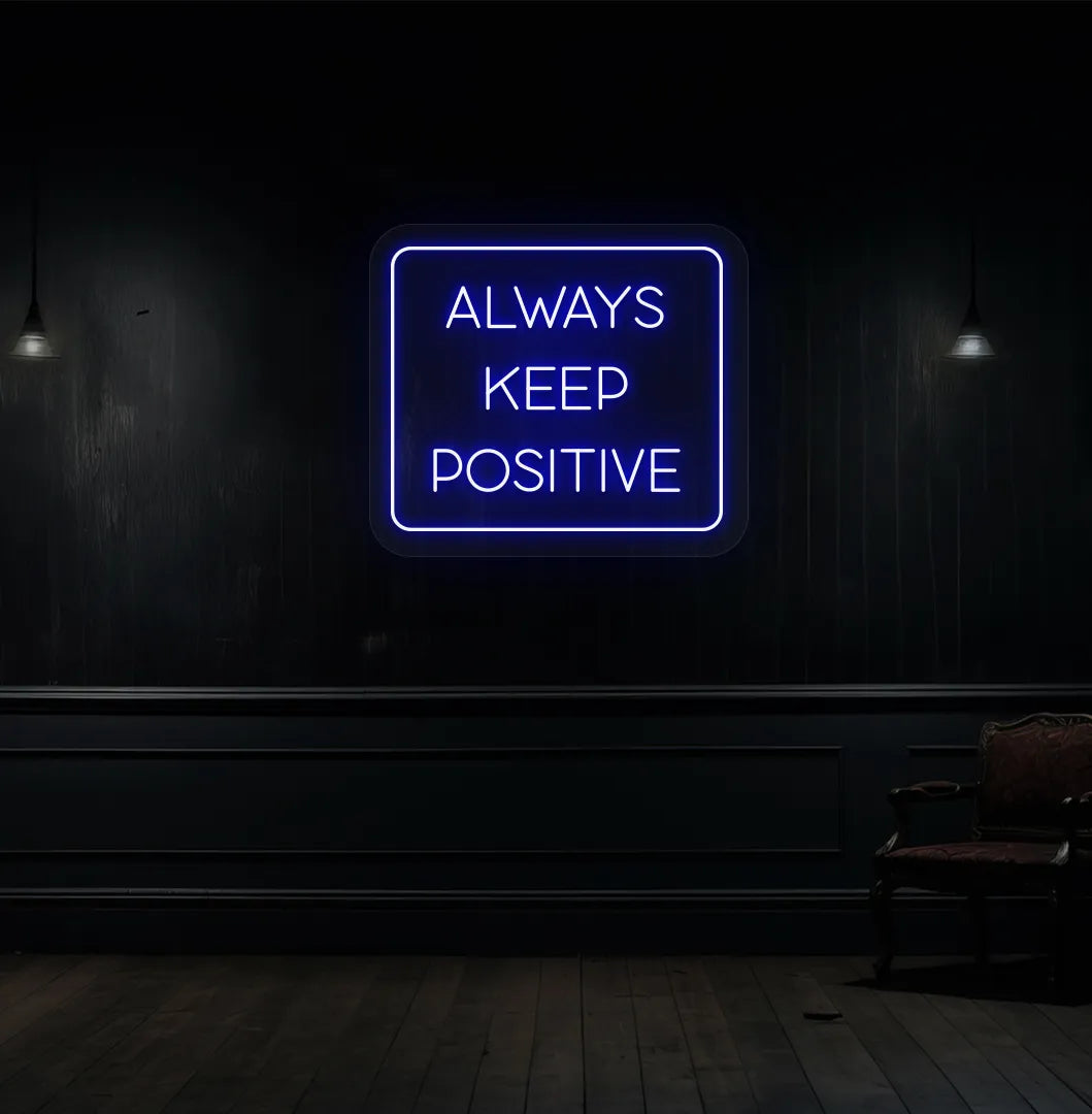 Image of an "Always keep positive" neon sign in blue color mounted on aesthetic wall.