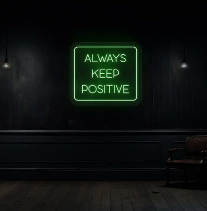 Modern aesthetic wall with "always keep positive" neon sign glowing green.
