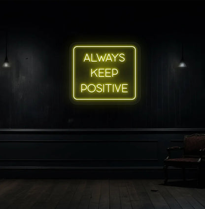 Modern aesthetic wall with "always keep positive" neon sign glowing yellow.