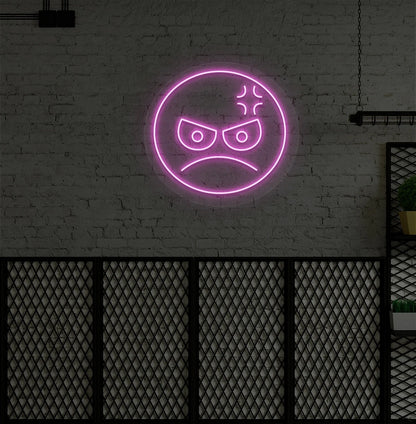 Image of an angry emoji neon sign glowing on aesthetic wall in pink color.
