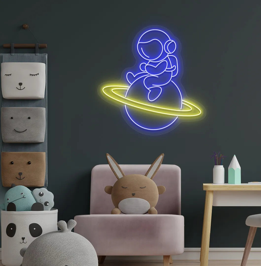 Stylish astronaut sitting on planet neon sign mounted on children's wall in blue color.