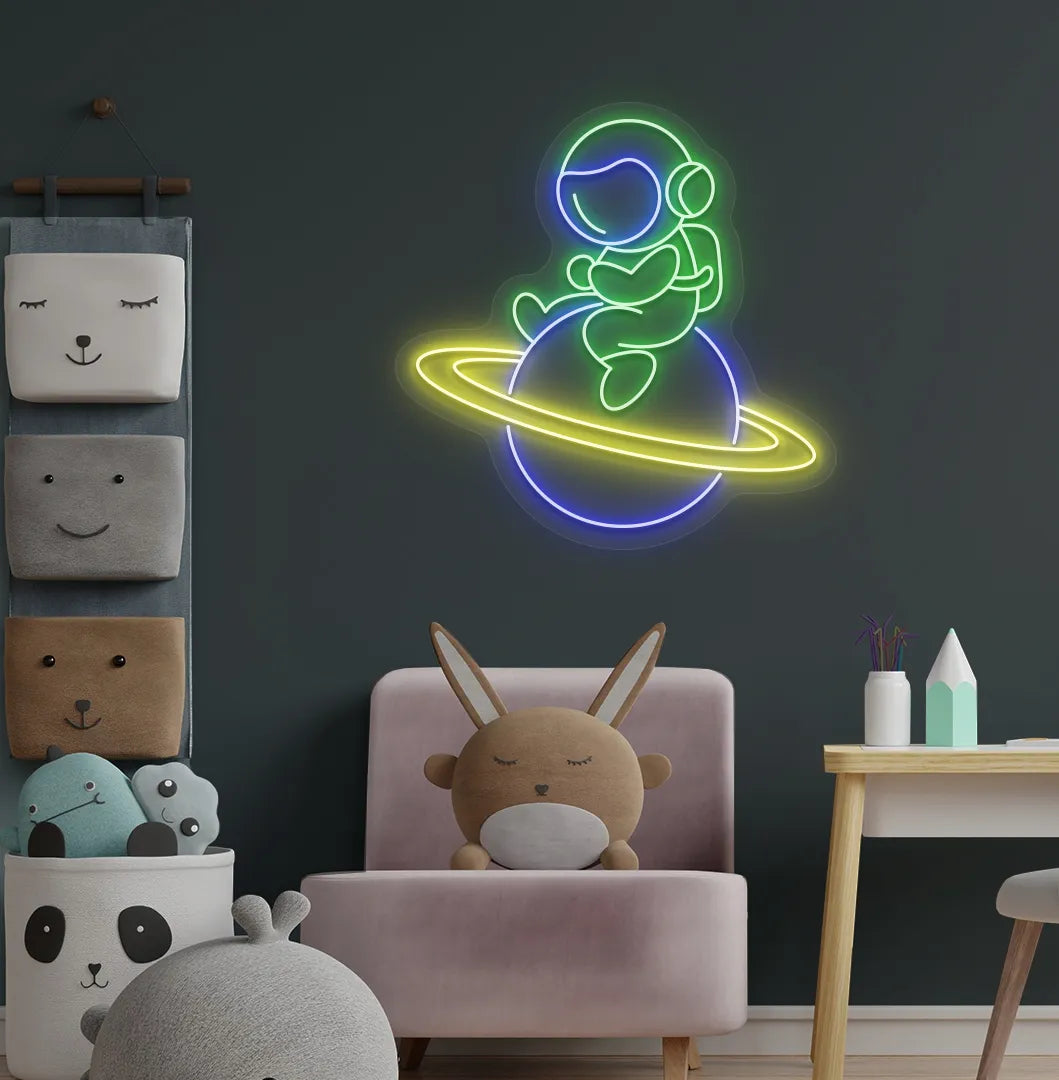 Green astronaut sitting on planet LED neon sign for space-themed bedroom.