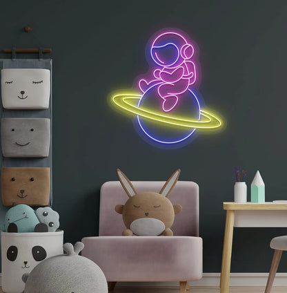 Purple astronaut sitting on planet LED neon sign for space-themed bedroom.
