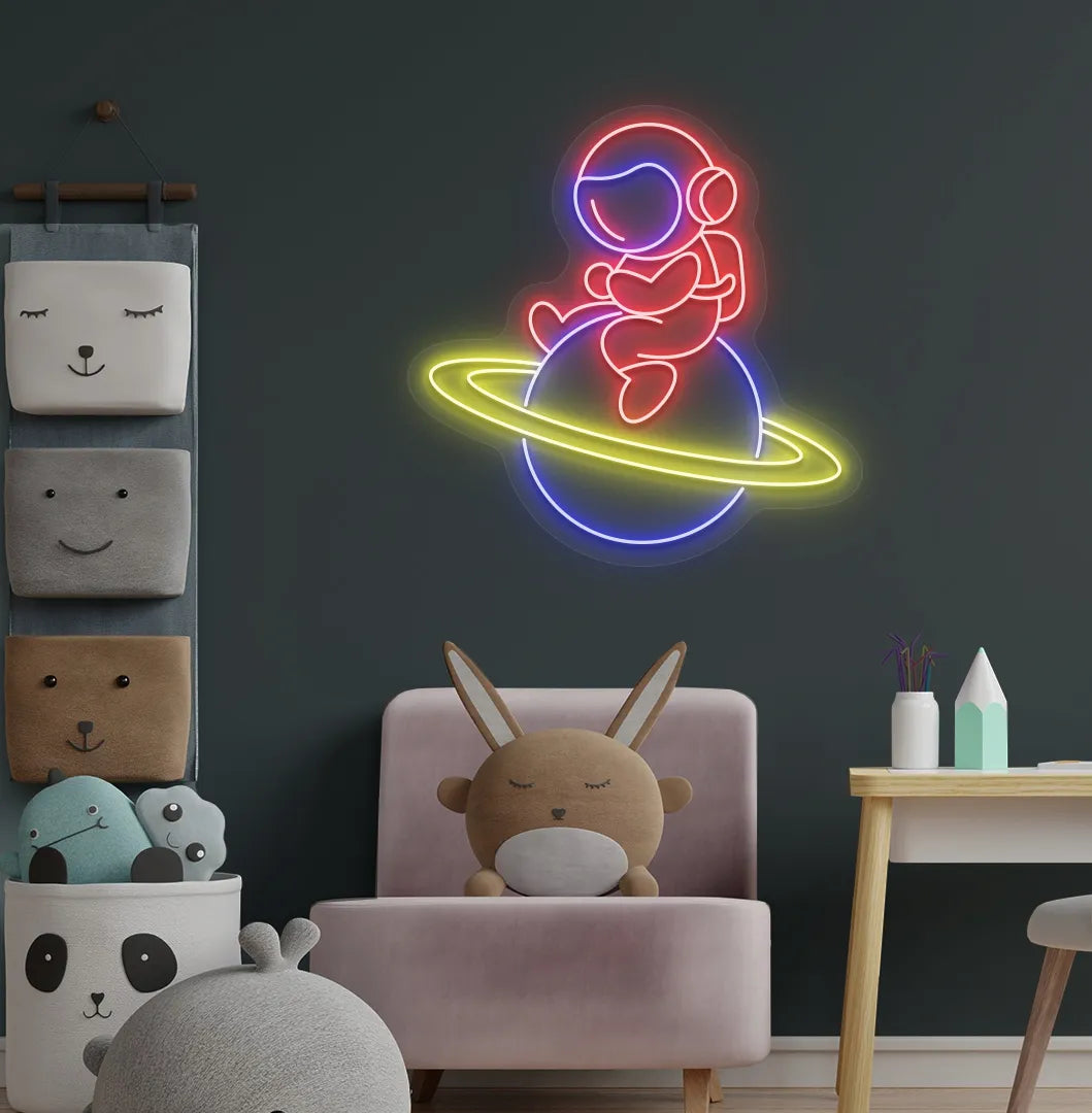 Stylish astronaut sitting on planet neon sign mounted on children's wall in red color.