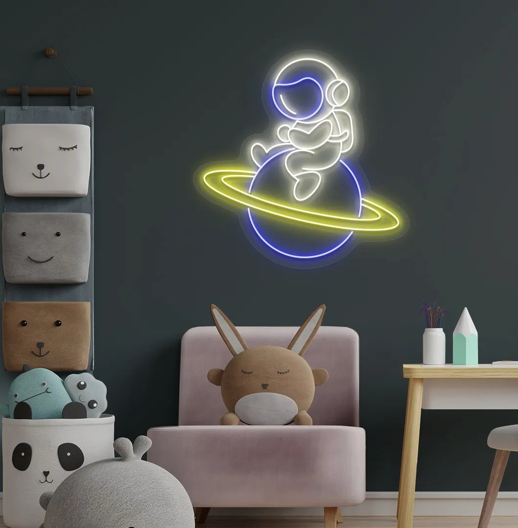 Warm white astronaut sitting on planet LED neon sign for space-themed bedroom.