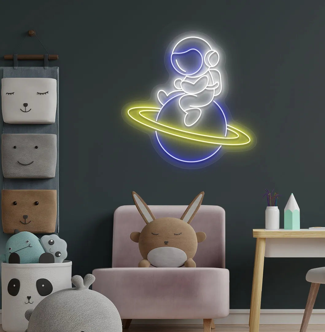 Stylish astronaut sitting on planet neon sign mounted on children's wall in white color.