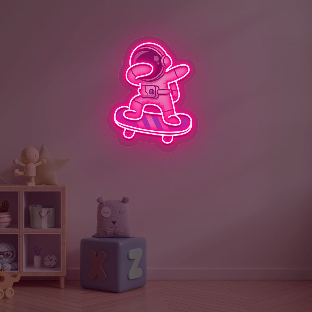 Image of an astronaut skateboard neon sign mounted on a kid's bedroom wall in pink color.