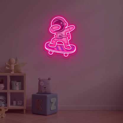 Image of an astronaut skateboard neon sign mounted on a kid's bedroom wall in pink color.