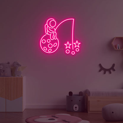 A creative pink LED astronaut neon sign catching stars glowing on a kid's room wall. Perfect for playrooms, space-themed interiors, and bedroom wall décor.