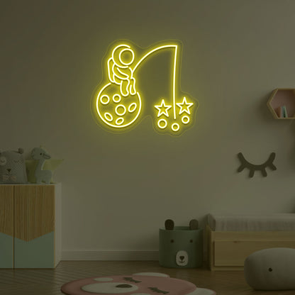 A creative yellow LED astronaut neon sign catching stars glowing on a kid's room wall. Perfect for playrooms, space-themed interiors, and bedroom wall décor.