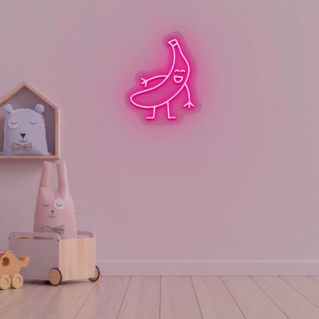 Image of a banana neon sign glowing on a kid's bedroom wall in pink color.