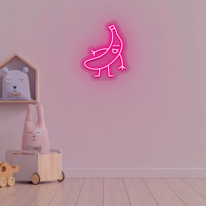 Image of a banana neon sign glowing on a kid's bedroom wall in pink color.