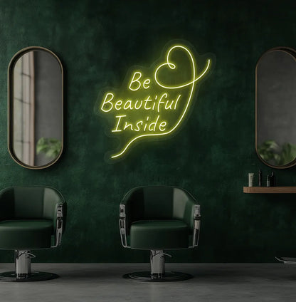 Modern salon aesthetic wall with "be beautiful inside" neon sign glowing yellow.