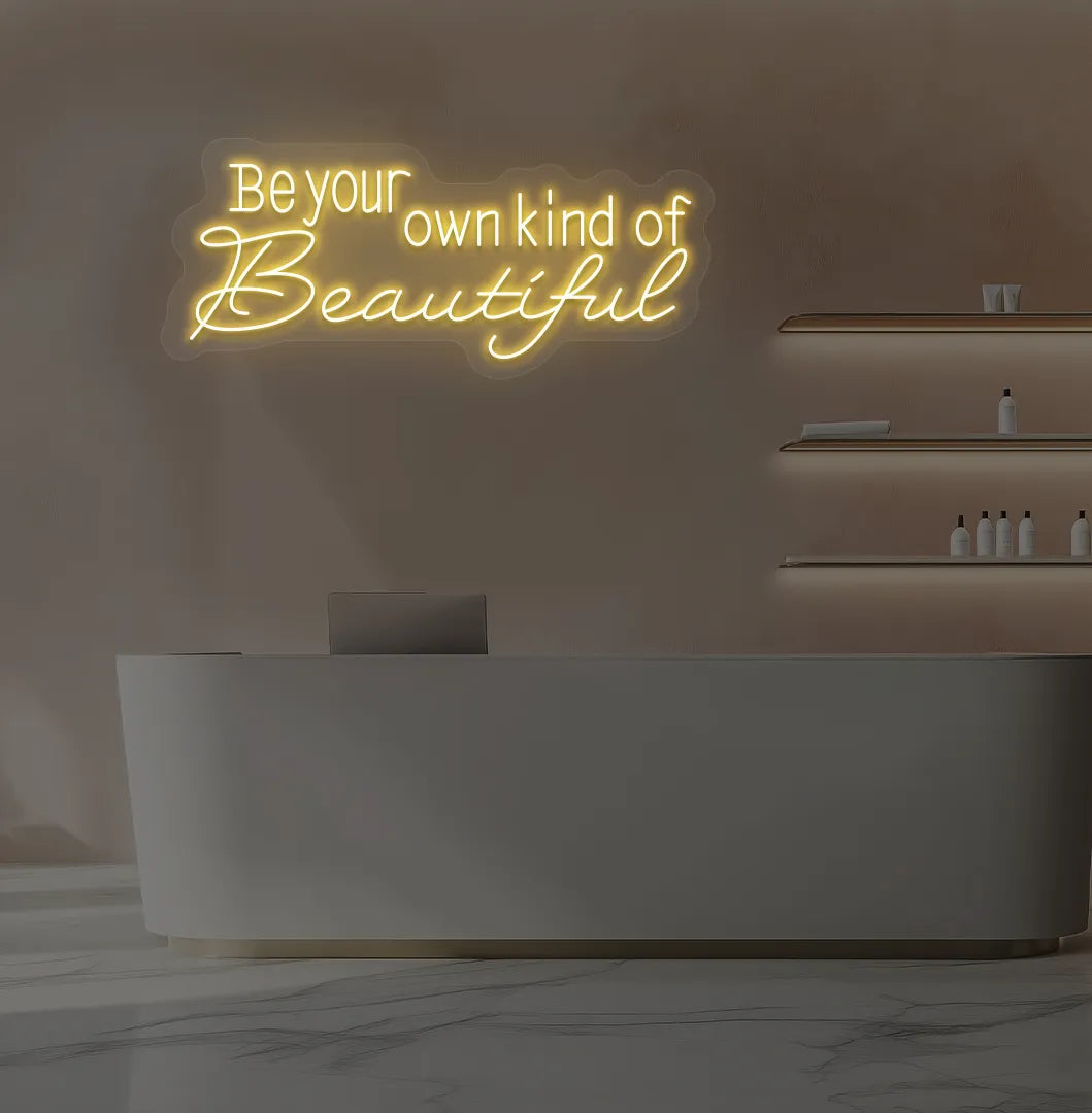 Orange "be your own kind of beautiful" LED neon sign for beauty studio setup.
