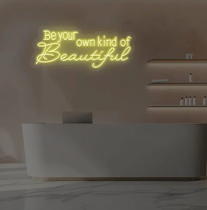 Yellow "be your own kind of beautiful" LED neon sign for beauty studio setup.
