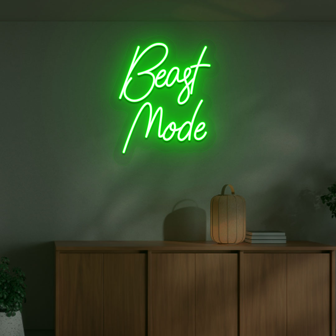 Image of a motivational "beast mode" neon sign mounted on a wall in warm green color.