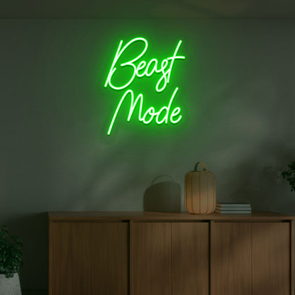 Image of a motivational "beast mode" neon sign mounted on a wall in warm green color.