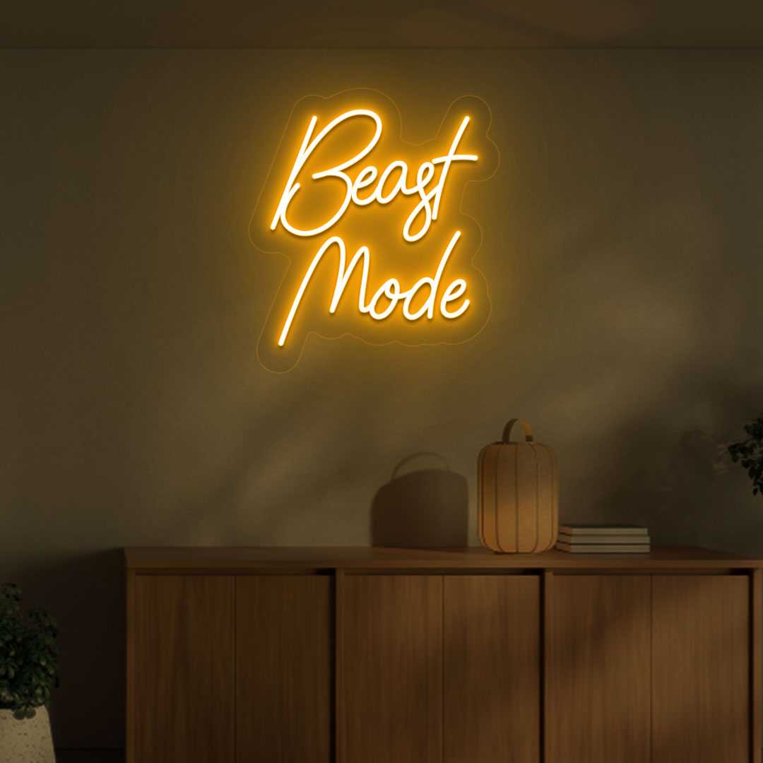 Image of a motivational "beast mode" neon sign mounted on a wall in warm orange color.