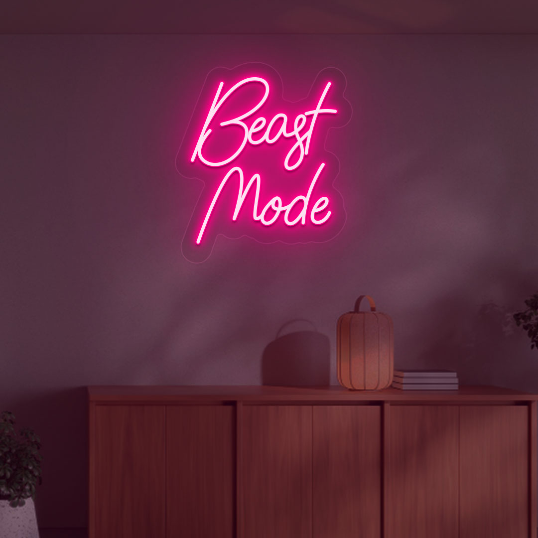 A stylish pink LED beast mode neon sign is glowing on the gym wall.
