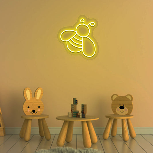 Image of a bee LED neon sign glowing on a kid's room wall in yellow color.