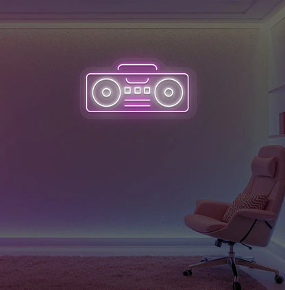 Stylish boombox LED neon sign in pink mounted on gaming room wall.