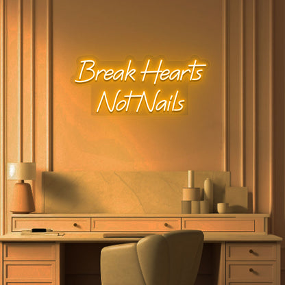 Image of a break hearts, not nails neon sign glowing on a salon wall in orange color.