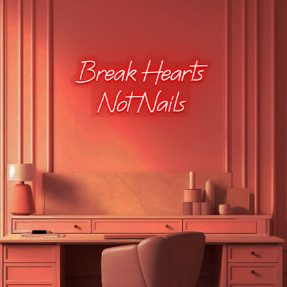 Stylish "break hearts, not nails" neon sign in red on the wall. Perfect for nail salons, beauty studios, and home nail art setups.