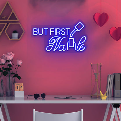 Image of a "but first nails" LED neon sign mounted on a salon wall in blue color.