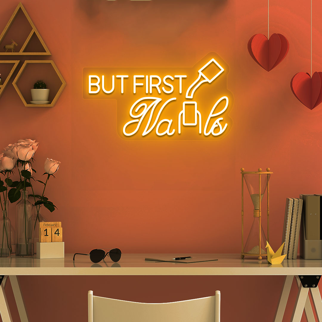 Stylish orange LED "But First Nails" neon sign mounted on salon wall. Perfect for nail salons, beauty studios, home nail art spaces, and salon storefront displays.