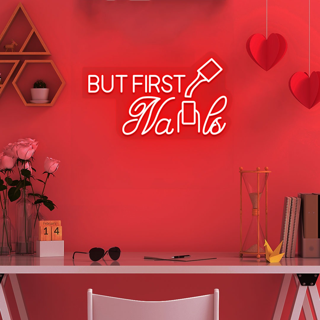 Image of a "but first nails" LED neon sign mounted on a salon wall in red color.