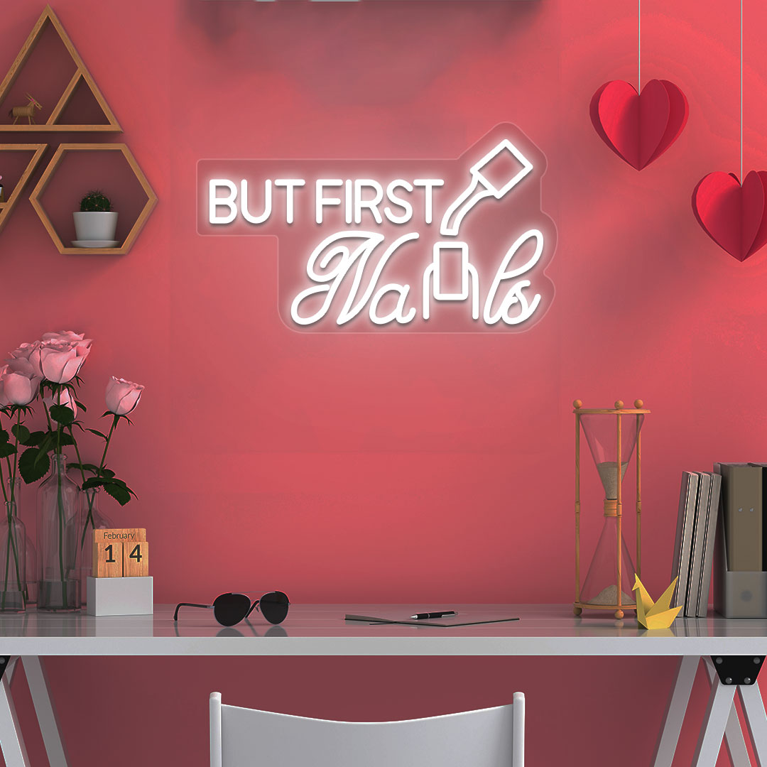 Beauty studio decor with warm white LED "but first nails" neon sign glowing on the wall.