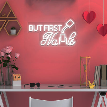 Beauty studio decor with warm white LED "but first nails" neon sign glowing on the wall.