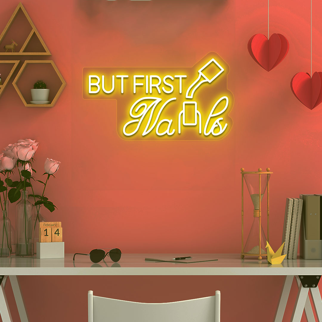 Image of a "but first nails" LED neon sign mounted on a salon wall in yellow color.