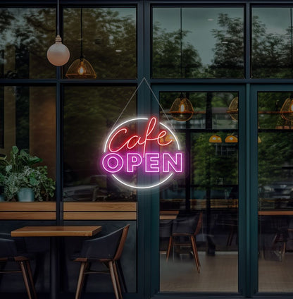 Image of a cafe's open neon sign glowing on the cafe glass door in pink.