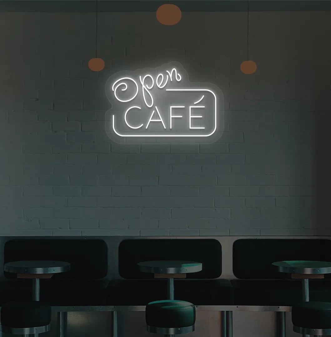 Image of a cafe wall with white cafe open neon sign glowing brightly.