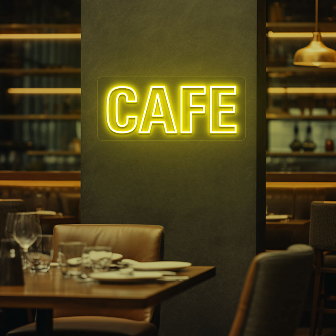 Coffee shop wall with yellow LED cafe neon sign glowing.