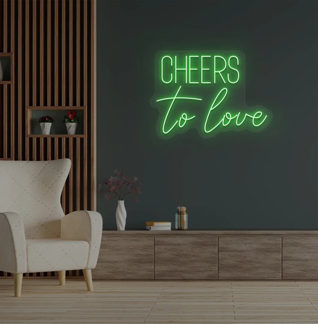 Image of a Romantic Cheers to Love green neon sign glowing on decorative wall.