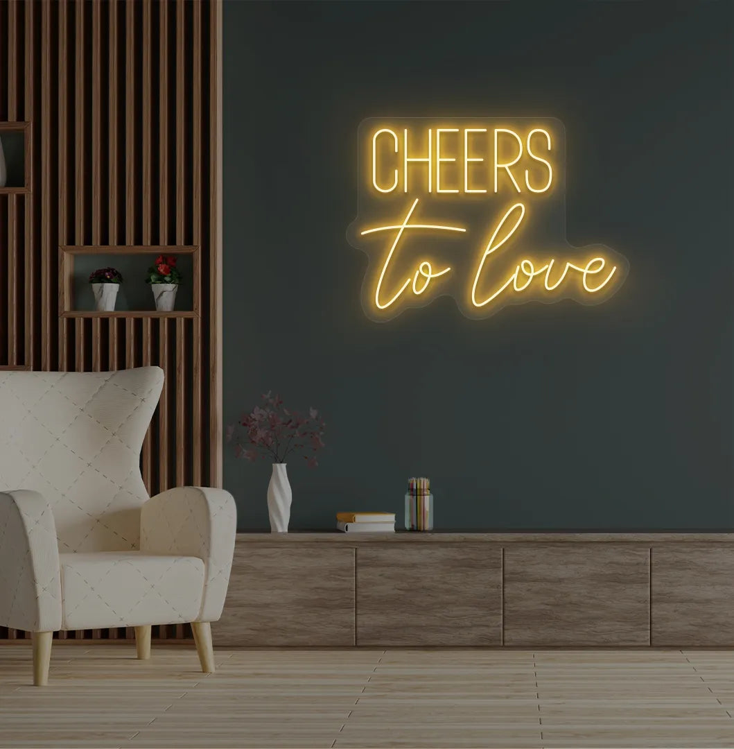 Image of a Romantic Cheers to Love orange neon sign glowing on decorative wall.