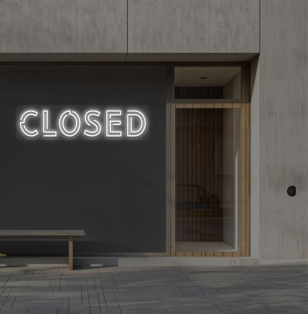 Image of a closed bold neon sign glowing on a shop exterior wall in white.