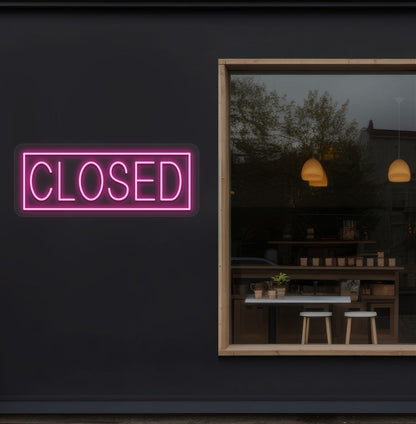 Image of a closed neon sign glowing on shop exterior wall in pink color.