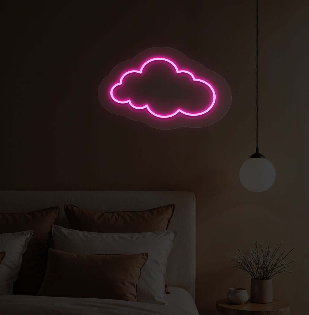 A pink cloud LED neon sign hanging on a bedroom wall for kids' room decor.