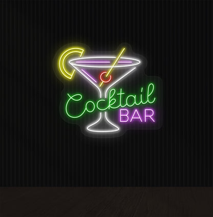 A cocktail bar neon sign with a cocktail glass, straw, and lemon glowing in the middle of the design in green light.