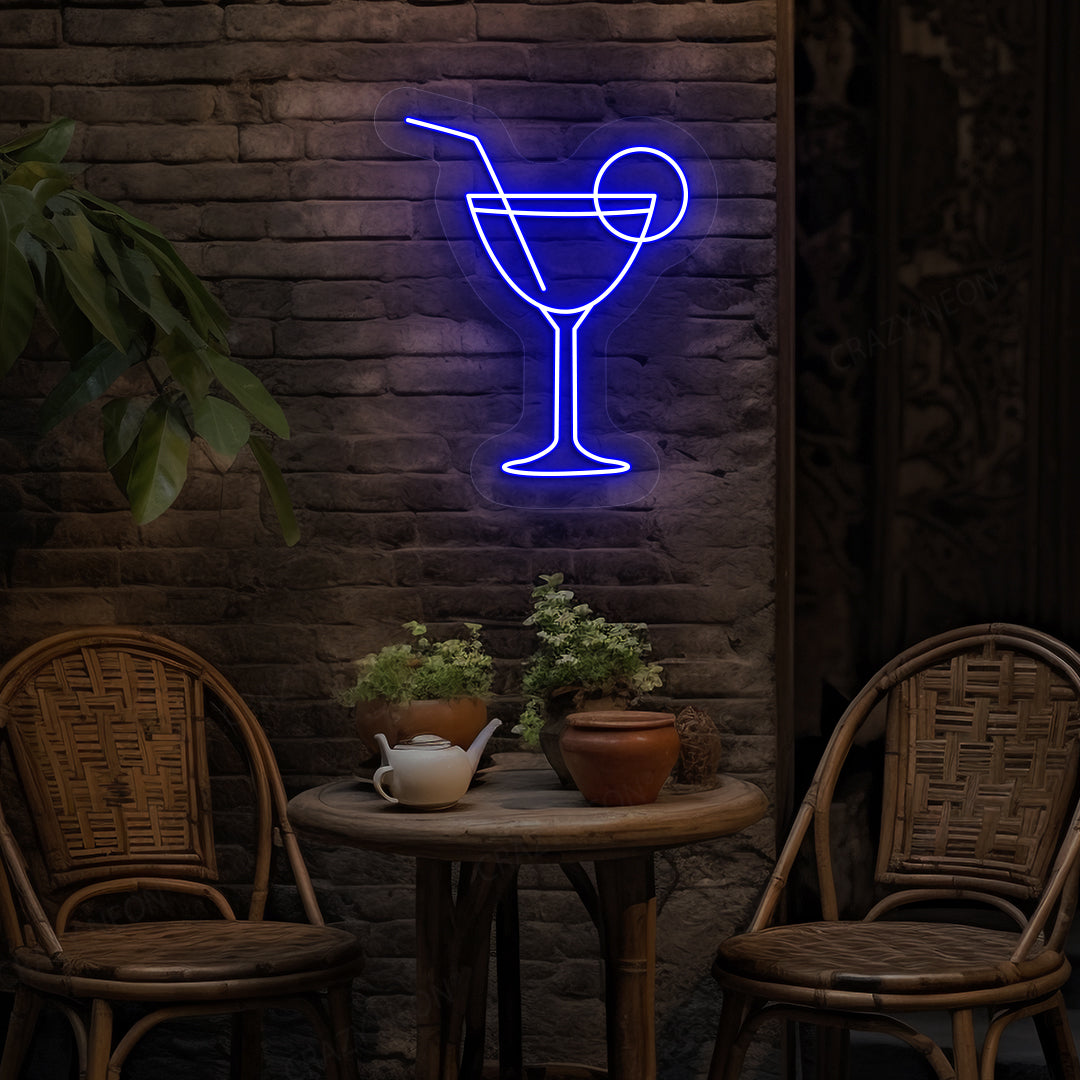 Image of a cocktail LED neon sign glowing on a bar wall in blue color.